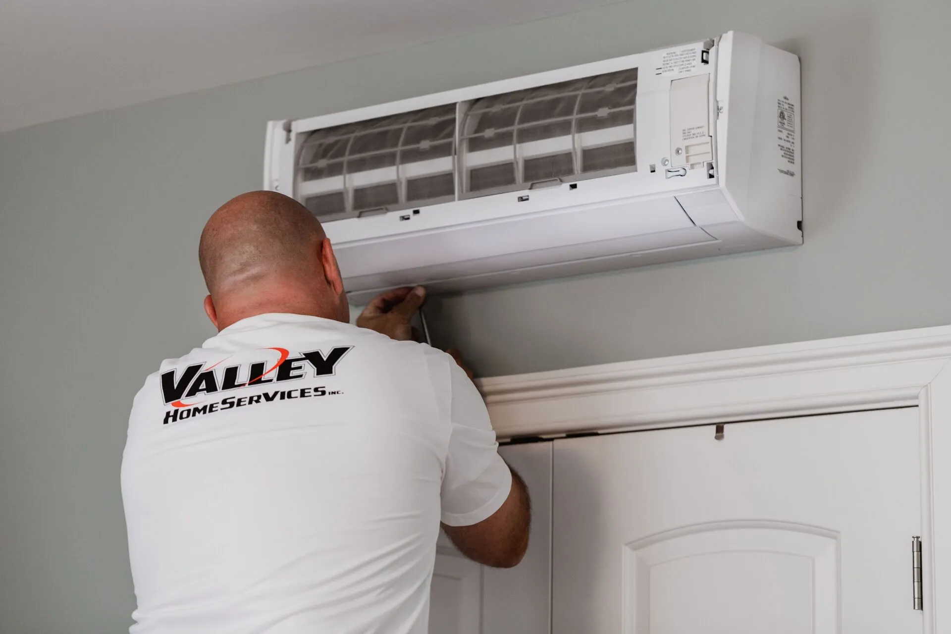 Valley Home Services technician installing a heat pump.